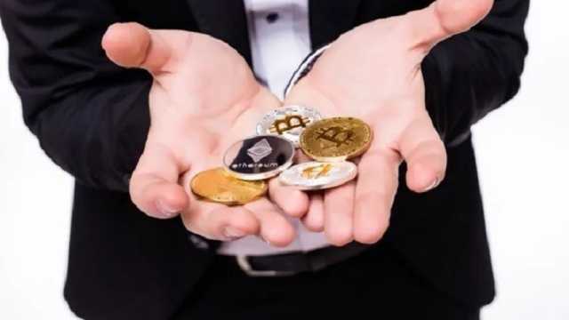 Hombre tiene diferentes monedas criptográficas en sus manos. (Foto: Freepik)